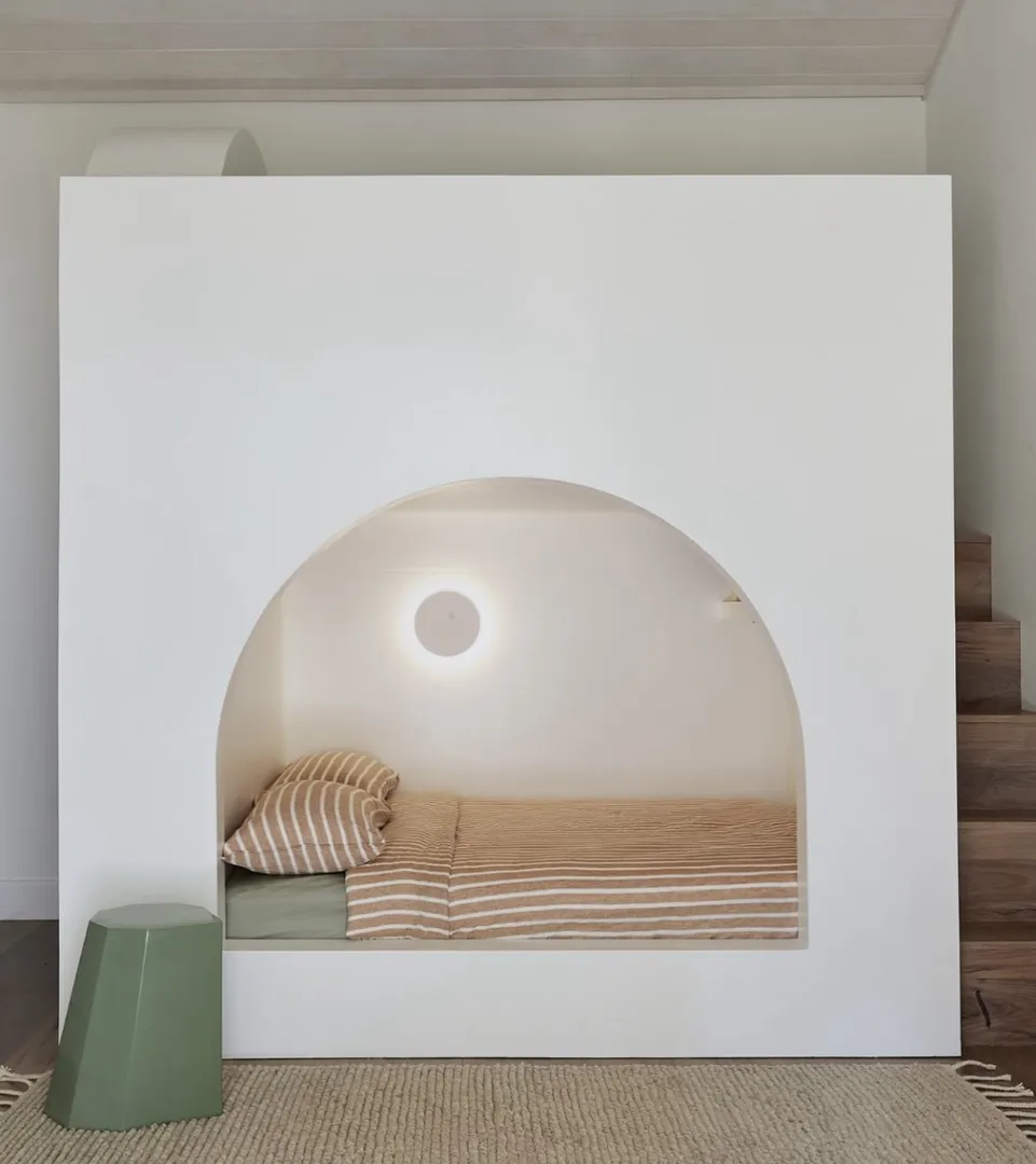 Modern minimalist bed nook with striped bedding.