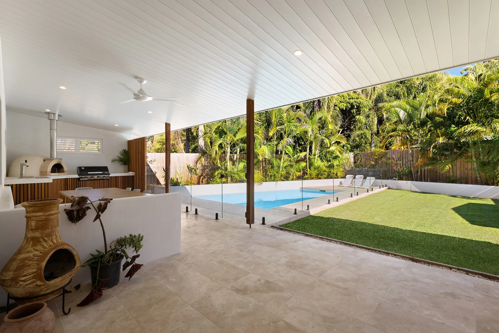 Covered patio with pool, BBQ, pizza oven, and garden.