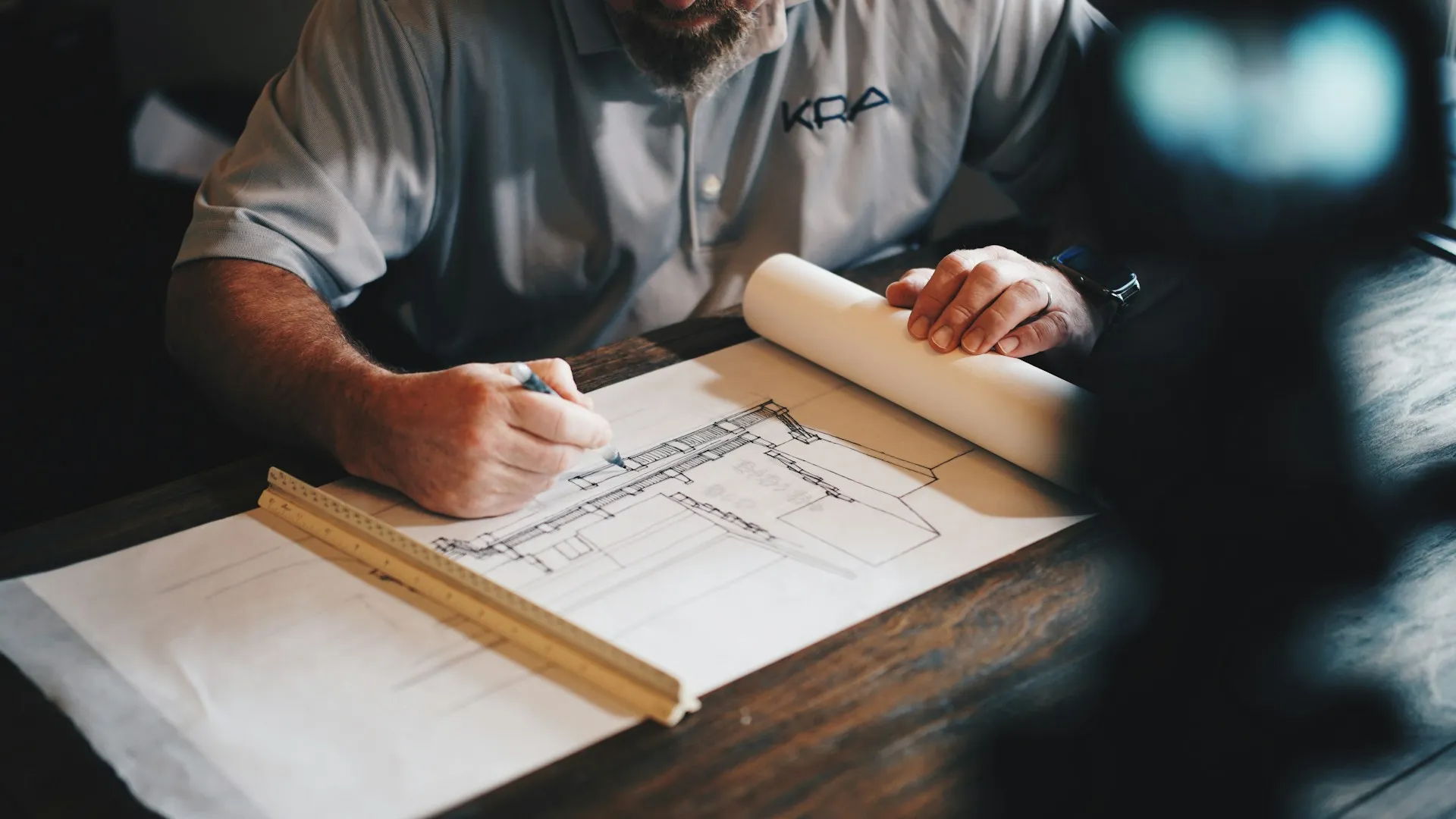 Architect drawing blueprint on a desk.