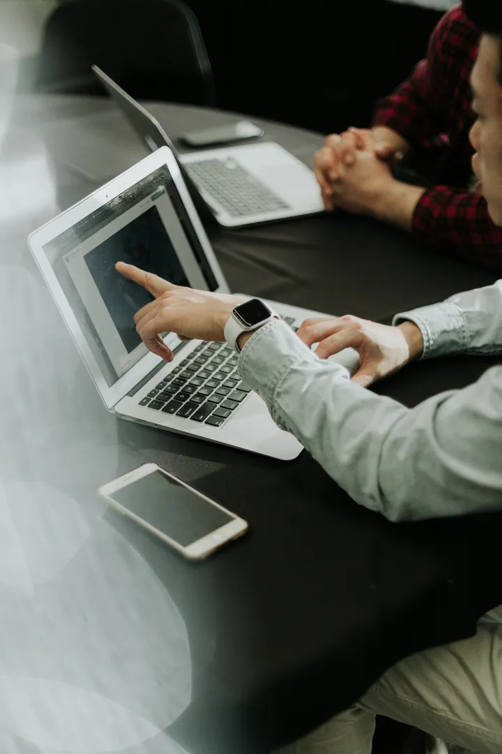 People collaborating on a laptop during a meeting.
